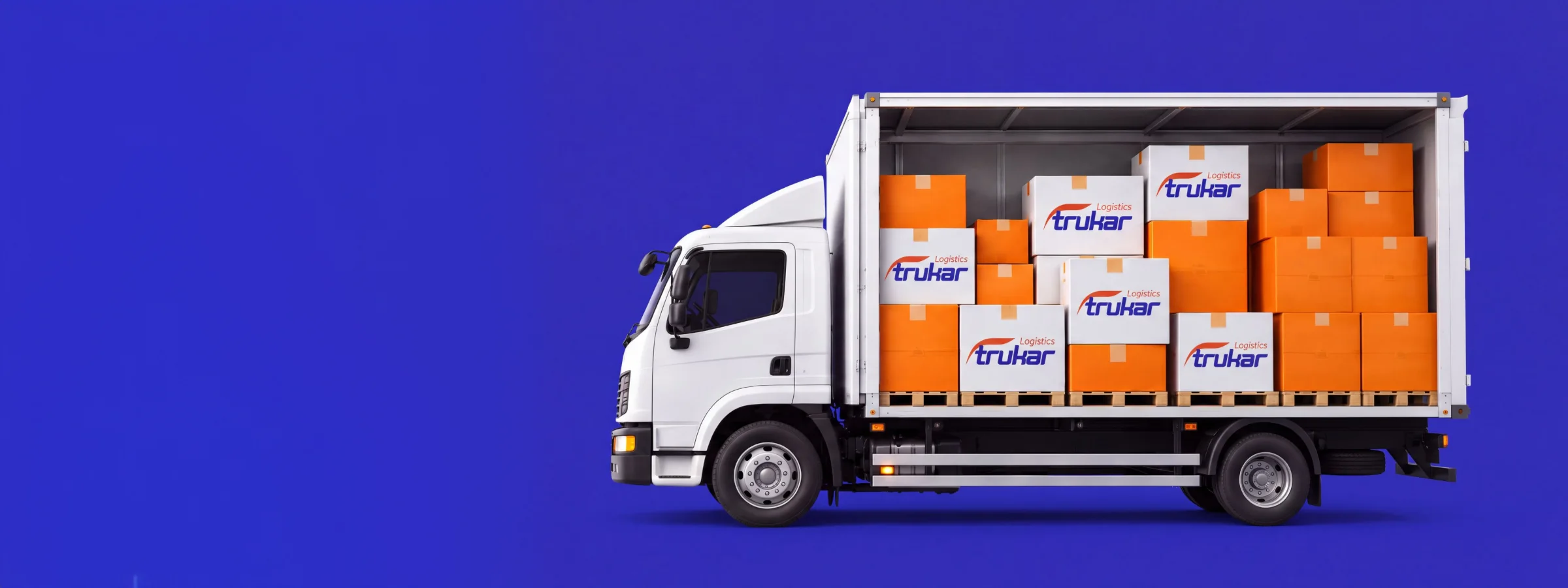 Weißer Trukar-LKW, beladen mit orange-weißen Markenkartons